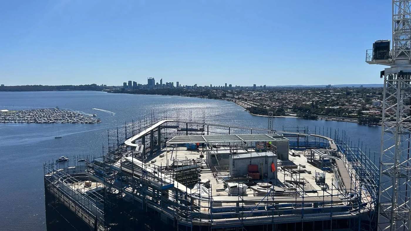 Rooftop structural works on a Perth high-rise overlooking the Swan River and the city skyline.