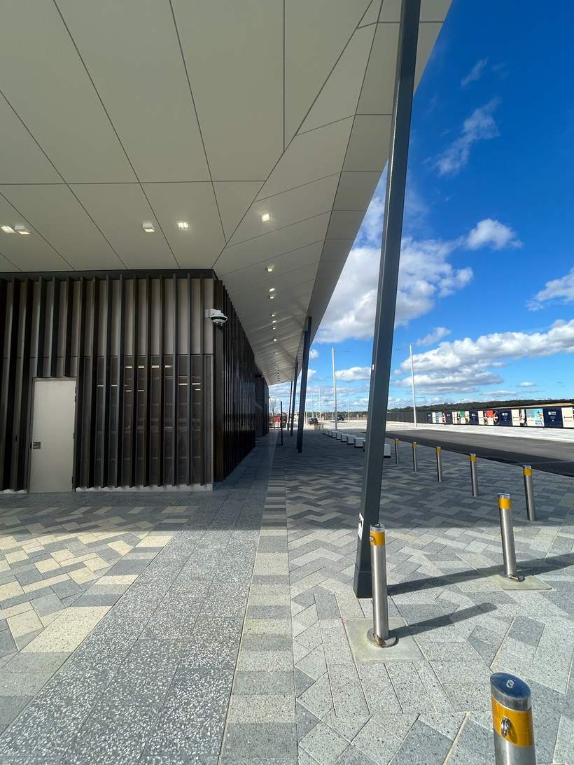 Covered walkway at Alkimos Station with cladded soffit overhead.