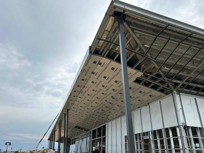 Cladding panels being installed to the station canopy with protective film still on.