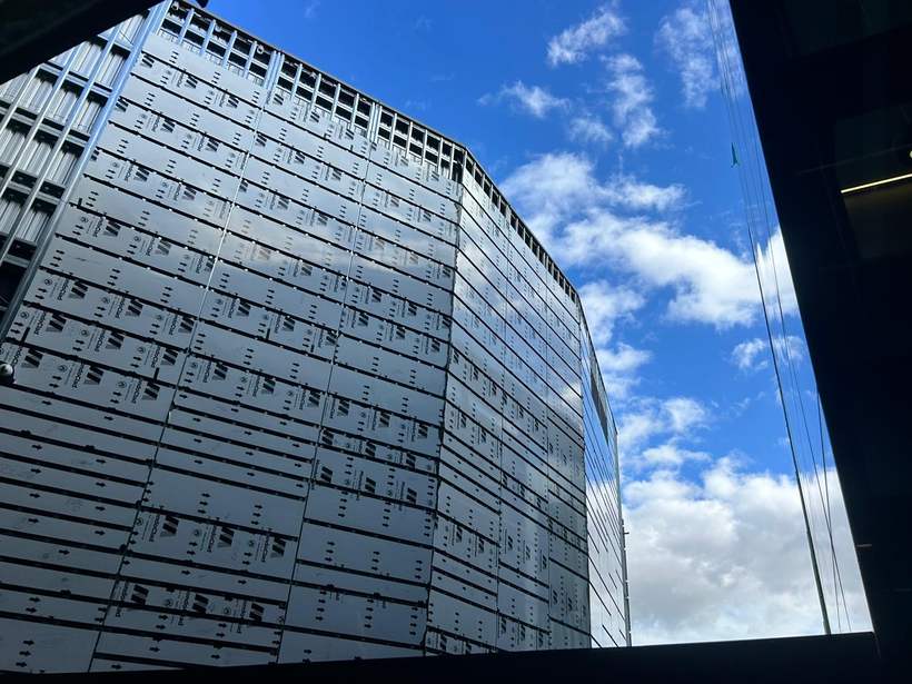 Cladding panels installed with protective film still on and sub-frame visible.