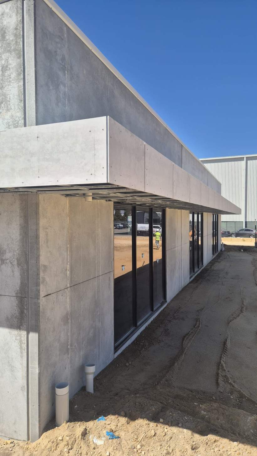Compressed fibre cement fascia and soffit to a factory unit awning.