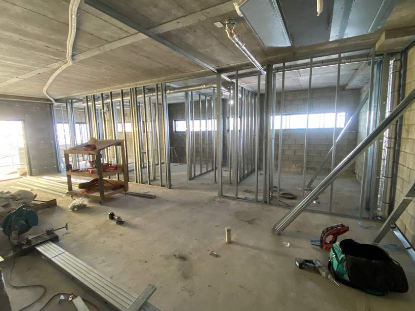 Steel stud framing against blockwork with services above.