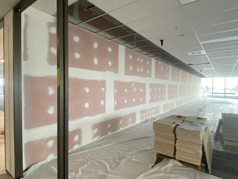 Plasterboard wall with joints and fixings flushed, awaiting paint.