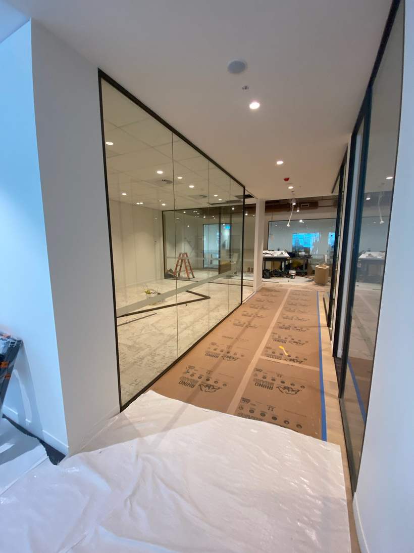Completed glazed office partitions with finished linings.
