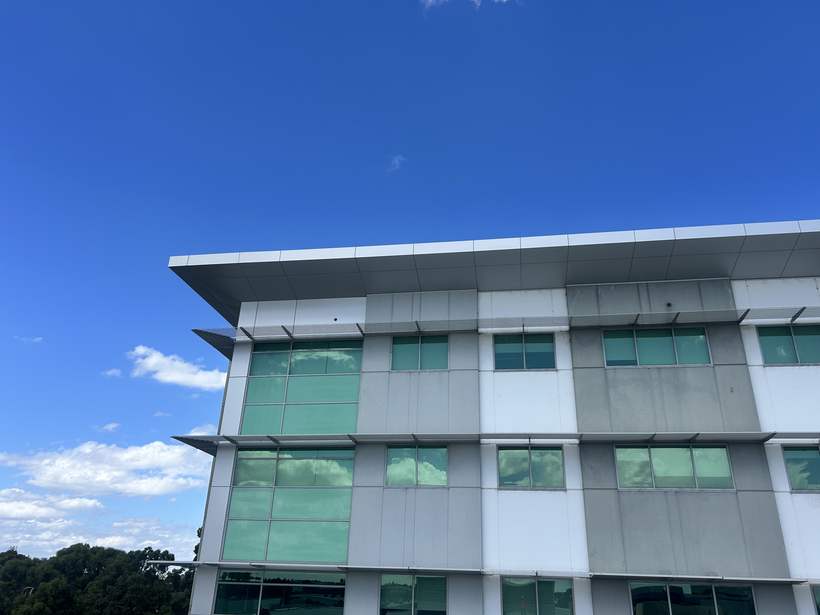 Completed reclad elevation with white panel fascia and sun hoods.