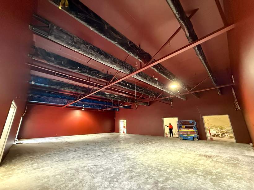 Performance space with acoustic wall linings and exposed structure above.
